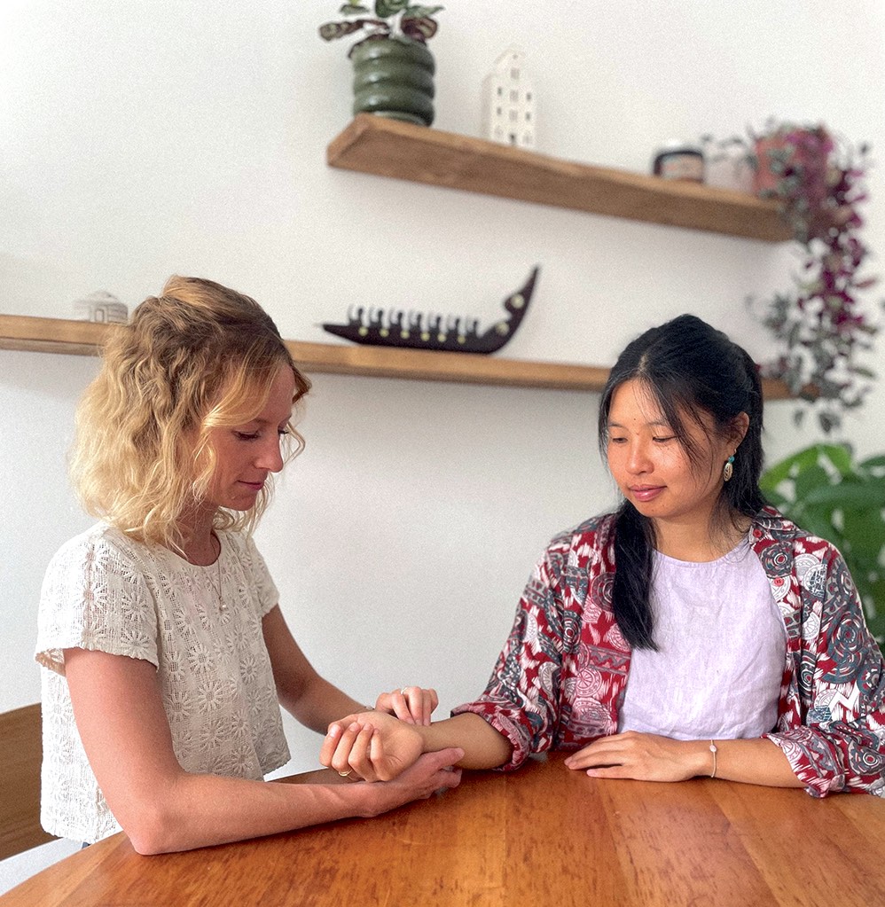 Astrid prend le pouls d'une cliente lors d'une consultation d'Ayurveda à Annecy